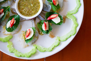 spicy raw shrimp in fish sauce on white plate, Thai food (top view)