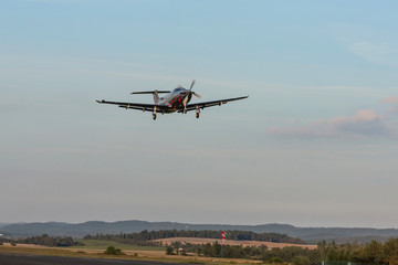 Single-engine turboprop aircraft departing from a small airport.