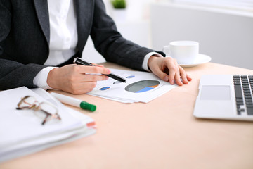 Business woman sitting at the table and examines the financial results