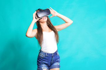 Sexy young girl with glasses of virtual reality on a blue background.