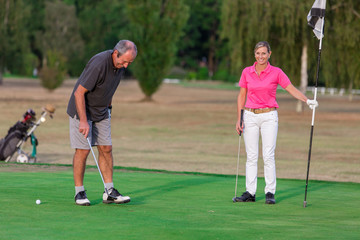 Senior Couple Enjoying Game Of Golf