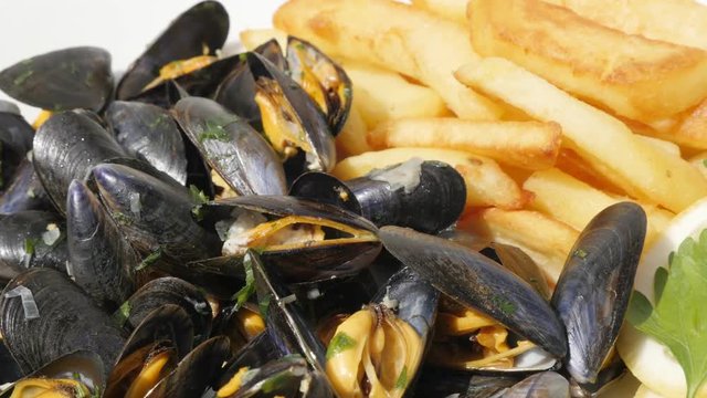Slices of potato and Mytilus edulis tasty sea product background 4K 2160p 30fps UltraHD footage - Blue common mussel with french chips fries and lemon food 3840X2160 UHD video 