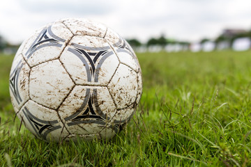 Muddy soccer ball on a football field.