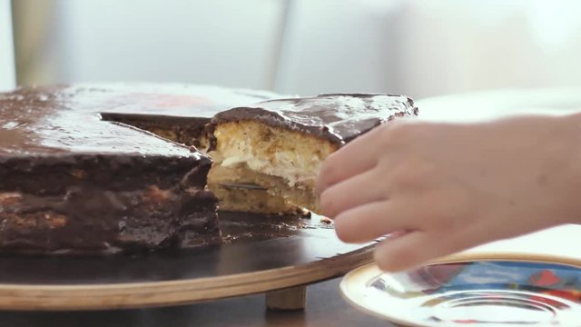 Person cutting a brown cake with a knife