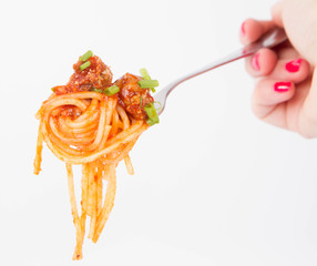 Spaghetti bolognese being eaten with a fork held by a woman's hand