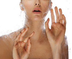 Close-up lips, hand and shoulders of young woman near mirror with water drops isolated on white...