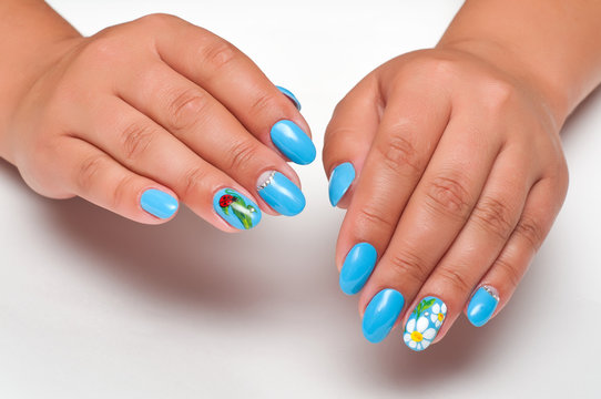summer blue manicure with daisies and lady-beetle on tanned hands