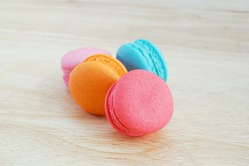 sweet macaroons on wooden background in soft focus
