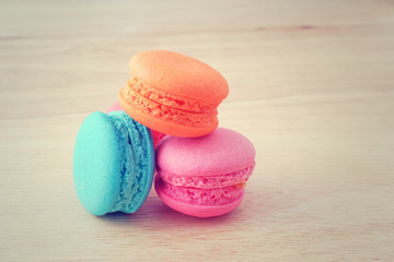 pastel color of  sweet macaroons on wooden background in soft focus