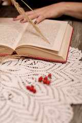 girl reading a book, mug of tea at a wooden table