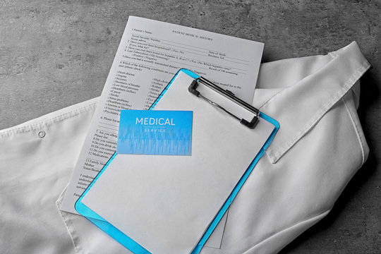 Medical service concept. Visiting card and clipboard on doctor uniform