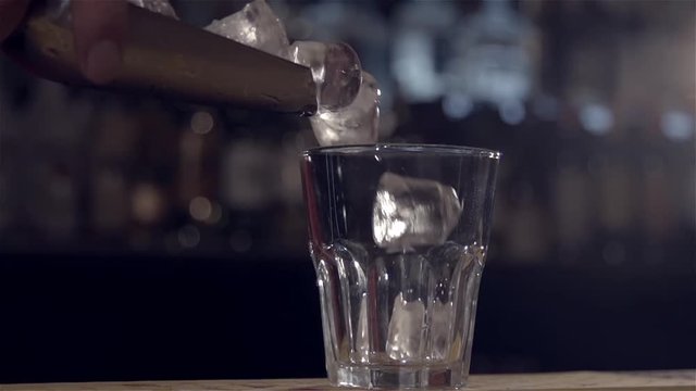 Dropping ice into a wineglass in slow motion