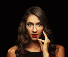 Obraz premium Beautiful young woman with make up and long wavy hair on black background