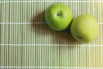 fresh green apple with water drop on bamboo wooden plate