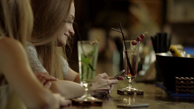 women gossiping sitting in a bar