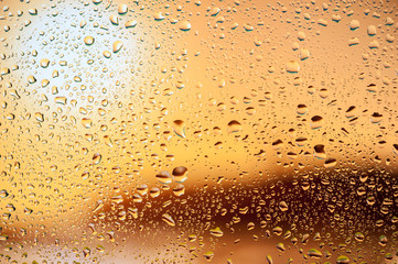 Abstract texture. Water drops on glass with sunset background