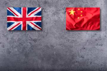 Flags of the united kingdom and china on concrete background.