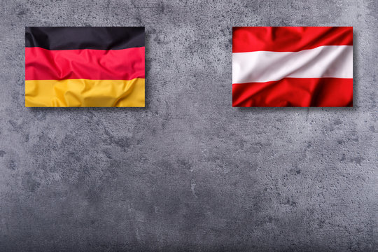 Flags of the germany and austria on concrete background.