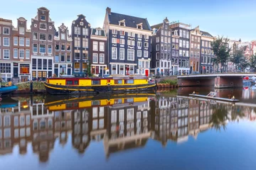Poster Amsterdamse gracht Singel met typisch Nederlandse huizen, brug en woonboten tijdens het ochtendblauwe uur, Holland, Nederland. © Kavalenkava