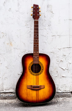 classical guitar of wood near a white wall © Yalana