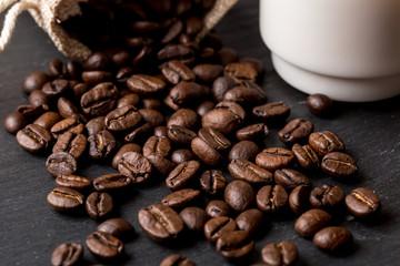 Cup of coffee with beans as background