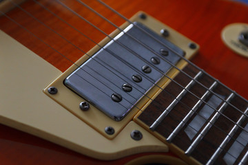 Closeup of the vintage electric guitar. Detail, selective focus. Low key.