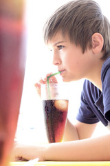 Garçon buvant un soda à la paille