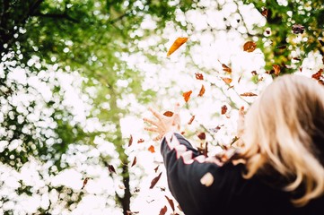 Herbst/Frau wirft Blätter in die Luft