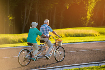Senior couple on tandem bicycle. Bike on the road. Faster than wind. The racer inside me.