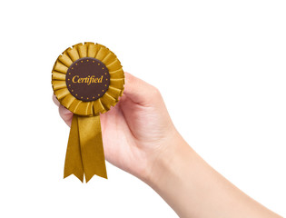 hand holding golden certified rosette on white background