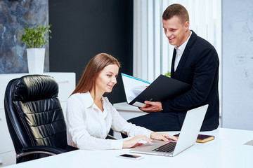 Happy executive or secretary giving documents to a businessman i