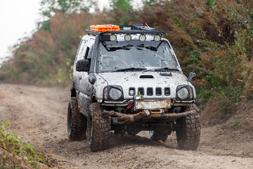 Plakat Small off-road car moving by dirt road