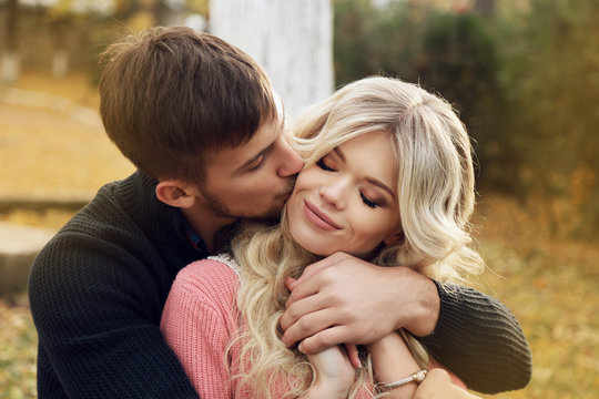 fashion outdoor photo of beautiful tender couple, wearing cozy clothes, walking by autumn park 