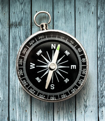 Black compass on wooden background