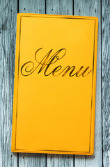 Yellow framed menu book on wood