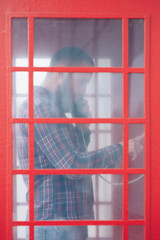 bearded man calling from a phone booth