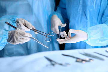 Medical team performing operation. Group of surgeon is working in operating theatre toned in blue