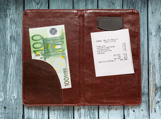 Open check folder with bill and euro
