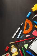 school supplies on black wood
