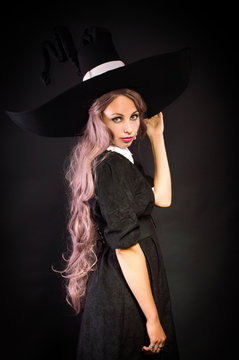 Witch in a big hat. On a black background.