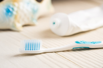 Fototapeta na wymiar Toothbrush with toothpaste on white wooden