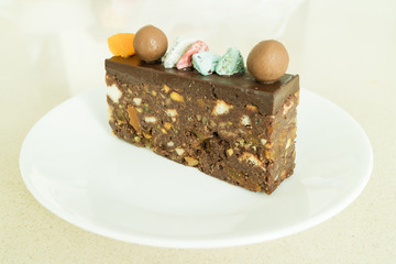 Tasty slice chocolate cake on top with chocolate ball and colorful sugar stone