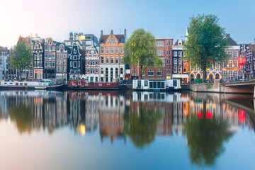 Fototapeta na wymiar Amsterdam canal Amstel with typical dutch houses and boats during sunrise, Holland, Netherlands.