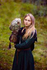 gorgeous girl in medieval dress with an owl on her arm