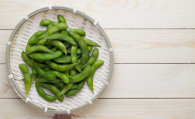 Green Japanese Soybeans in bamboo basket on wooden background