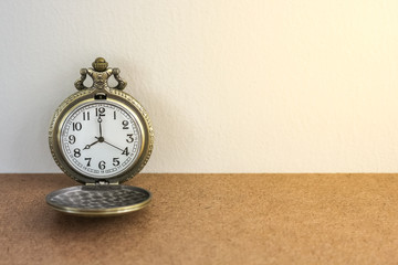 luxury vintage black pocket watch on wood table, abstract for time concept with copy space