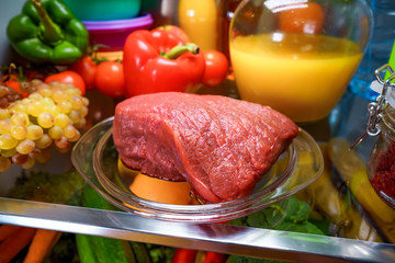 Fresh raw meat on a shelf open refrigerator