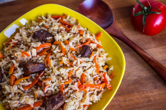 Photo of dish of uzbek pilaf made of rice and carrots, meat and onions