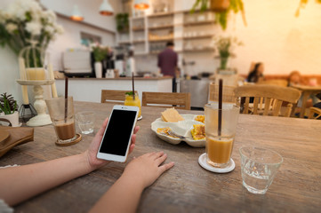 Woman using phone in cafe