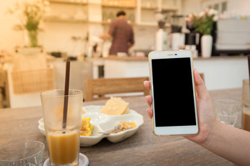 Woman using phone in cafe